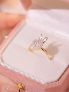 Dettaglio ravvicinato di un anello a coniglio rotante con cristalli in una scatola regalo