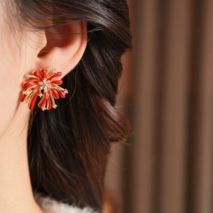 Gros plan de boucles d'oreilles fleur feu d'artifice rouge sur un mannequin femme