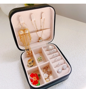 Detail of portable square jewelry box with necklace hooks and rings storage sections