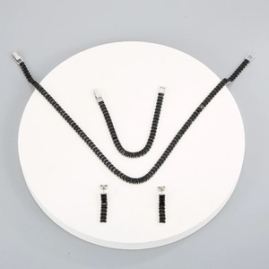 Detailed flat lay of luxury titanium jewelry set with black rectangular zircon stones