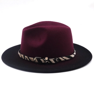 Dettaglio cappello fedora bicolore bordeaux e nero con cintura zebrata e fibbia in metallo