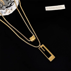 Double-layered gold titanium steel necklace with cylindrical and geometric pendants