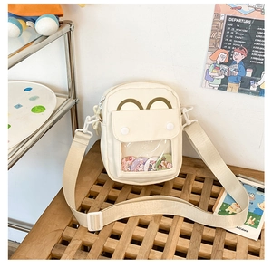 Detail of cute beige canvas bag featuring a clear display window and adjustable strap