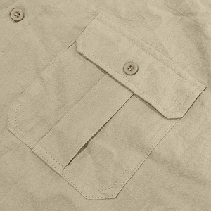 Detail of khaki linen shirt featuring chest flap pocket and slub fabric texture
