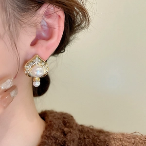 Nahaufnahme der Vintage Herz-Perlenohrringe mit Diamanten und Vergoldung am Modell