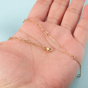 14K gold plated stainless steel paperclip link bracelet held in hand for scale