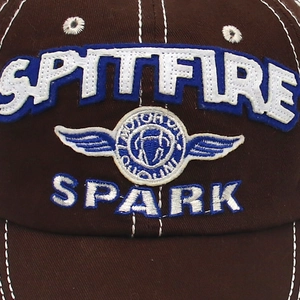Close-up of SPITFIRE 3D embroidery and white contrast stitching on brown canvas baseball cap