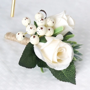 Macro shot of white silk roses and berries boutonniere with rustic jute twine wrap