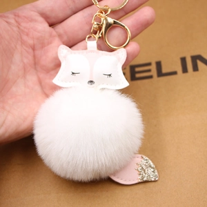 Detail of fox plush keychain with pink PU leather head and white faux fur ball