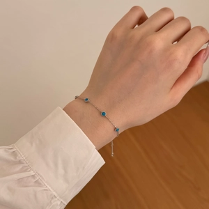 Detailed view of S925 sterling silver bracelet with five round blue opal gemstones on wrist