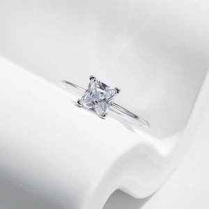 Bague classique en argent sterling S925 avec diamant carré sur fond blanc ondulé