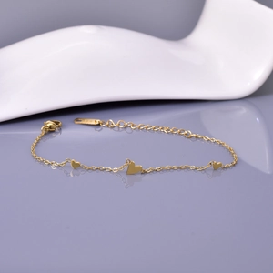 Minimalist 18K gold-plated stainless steel bracelet with three heart charms on grey background