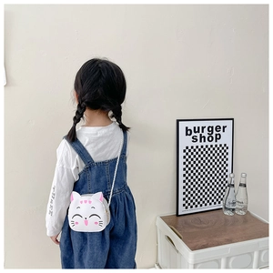 Toddler girl wearing white cartoon cat crossbody bag with cute ears shown from back