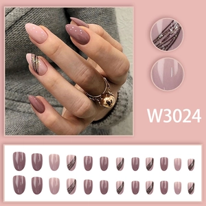 Detail of mauve and pink press-on nails set with gold glitter and stripe accents