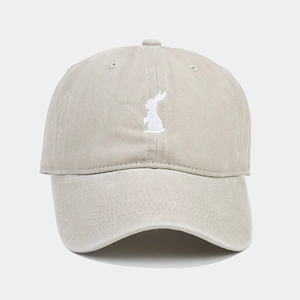 Detail of white rabbit embroidery on a vintage washed cotton baseball cap in khaki