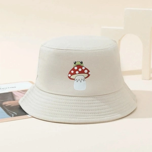 Detail of mushroom frog embroidery on a beige cotton sun hat with a minimalist setup