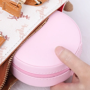 Portable round pink PU leather jewelry box with zipper stored in a stylish handbag
