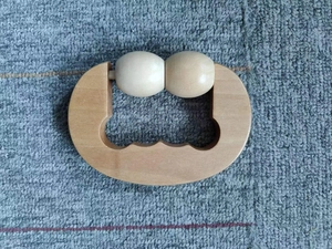 Detail eines Handmassagegeräts aus Holz mit Doppelrollen für die Körpermassage