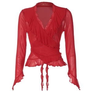 Détail du haut en maille rouge avec décolleté en V plongeant et volants délicats
