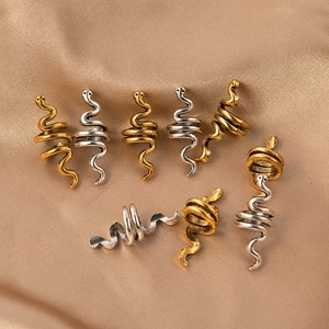 Set of 8 gold and silver spiral snake hair rings on a beige silk background