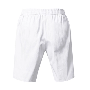 Detail of white linen beach shorts featuring elastic waistband and breathable fabric texture