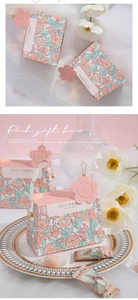 Pink floral wedding favor box with a white ribbon and a flower-shaped gift tag