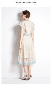 Detail view of lace dress featuring blue floral trim and flutter sleeves on the back