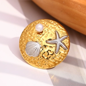 Detailed view of 18K gold plated ring with silver starfish, shell and white pearl