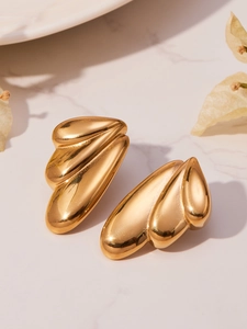 Detailed close-up of 18k gold plated stainless steel angel wing earrings on marble