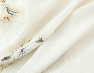 Nahaufnahme von weißem Mischgewebe mit gelben und blauen Blumenmustern und weicher Textur