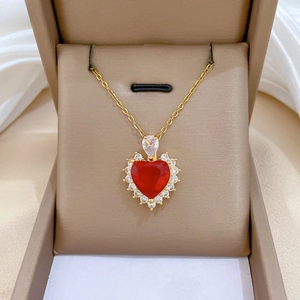 Close-up of heart-shaped red gemstone necklace with luxury white zircon pavé setting