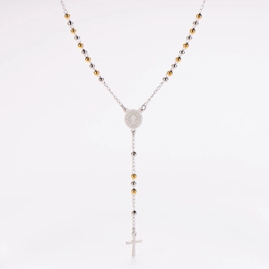 Macro shot of silver and gold St. Benedict medal pendant on a rosary necklace