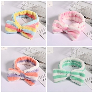 Detail showing colorful striped coral fleece headbands with large bows for skincare