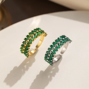 Close-up of gold and silver adjustable rings set with vibrant green zircon stones