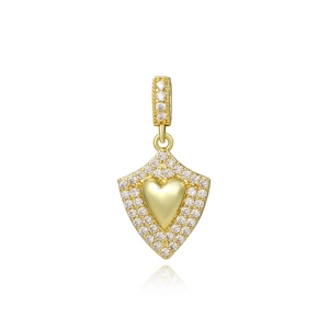 Golden heart and shield pendant set with sparkling zircons on a white background