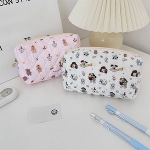 Close-up of quilted pencil cases with cute bear and dog prints and zipper closure