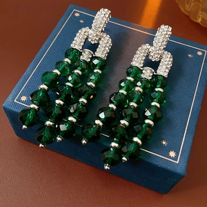 Nahaufnahme von Vintage-Silberohrringen mit smaragdgrünen Perlen und glitzernden Zirkonia