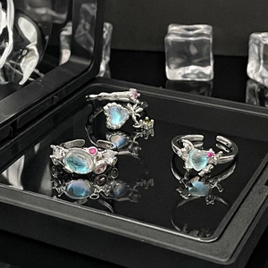 Detailed view of silver rings featuring heart-shaped moonstones in a black jewelry box