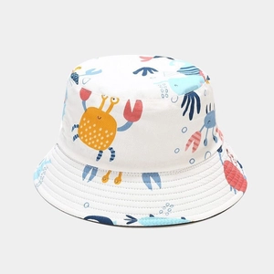 Detail of white cotton bucket hat featuring colorful cartoon crab and seagrass patterns