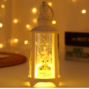 Close-up of white Christmas LED lantern with cartoon reindeer design and warm glowing light