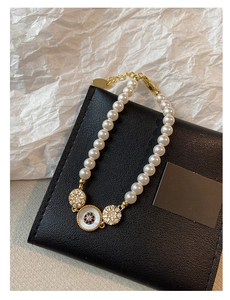 Détail d'un bracelet en perles plaqué or 18 carats avec œil protecteur et cristaux