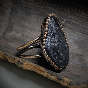 Detail of a large teardrop black stone ring with vintage bronze beaded edging