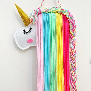 Détail du support mural licorne en feutre avec fils colorés pour ranger les barrettes