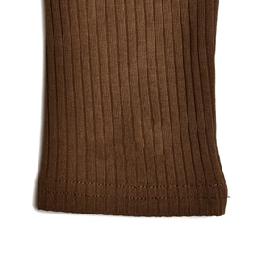 Close-up of brown ribbed knit cotton fabric showing soft texture and double stitching detail