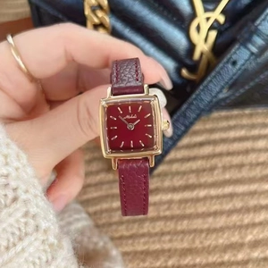 Luxury gold square watch for women with red leather strap and red dial in a lifestyle shot
