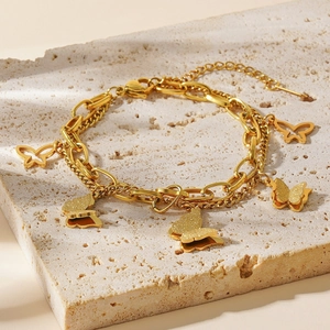 Detail of 18k gold double-layer butterfly bracelet featuring hollow and frosted charms