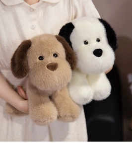 Dettaglio di morbidi peluche a forma di cucciolo color oro e bianco in un interno