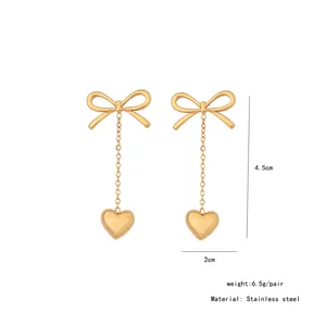 Detailed view of gold bow and heart earrings with size 4.5cm by 2cm and weight 6.5g