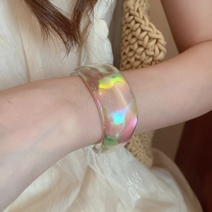 Iridescent acrylic cuff bracelet with aurora color flow shown on a model wrist