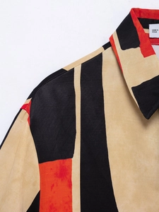 Close-up of beige shirt neckline with black and red geometric print and fabric texture